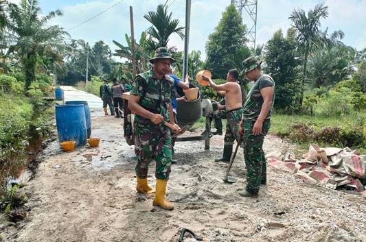 Lanjutkan Semenisasi Jalan Bunga Tombak di Bawah Teriknya Mentari, Satgas TMMD 114 Sampai Buka  Baju