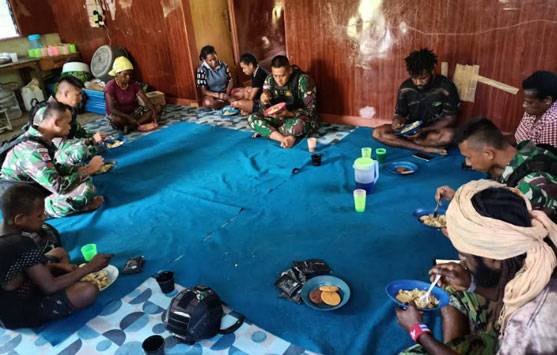 Satgas Yonif R 142/KJ Masak dan Makan Bersama Warga dengan Makanan Khas TNI