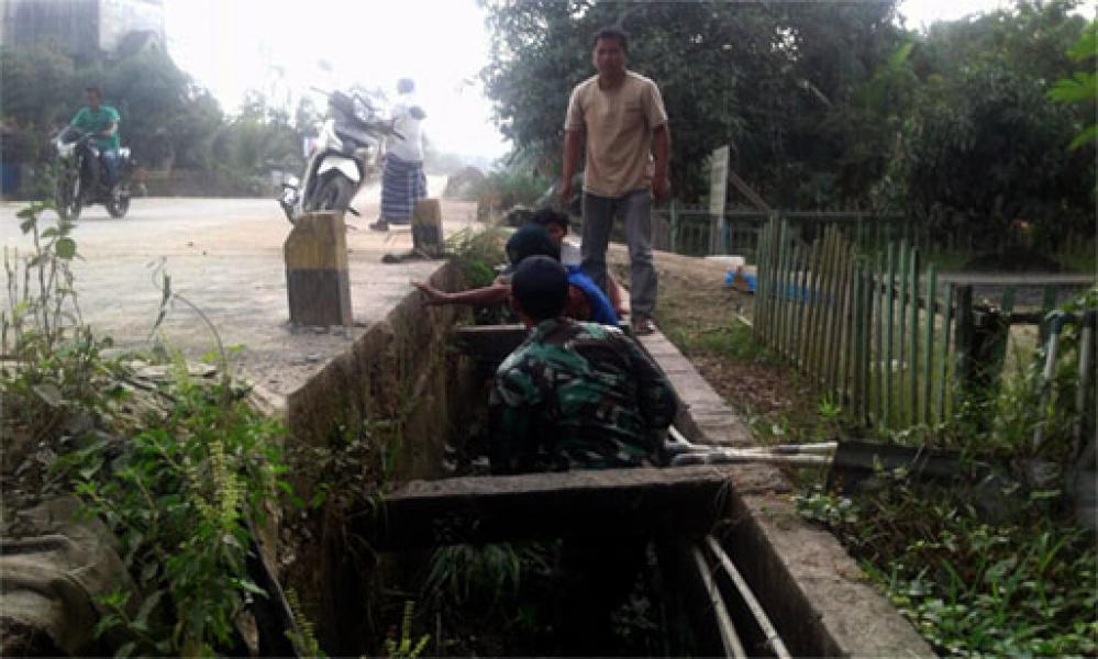 Babinsa Dan Masyarakat Bersihkan Parit Sepanjang Pasar Kota Baru