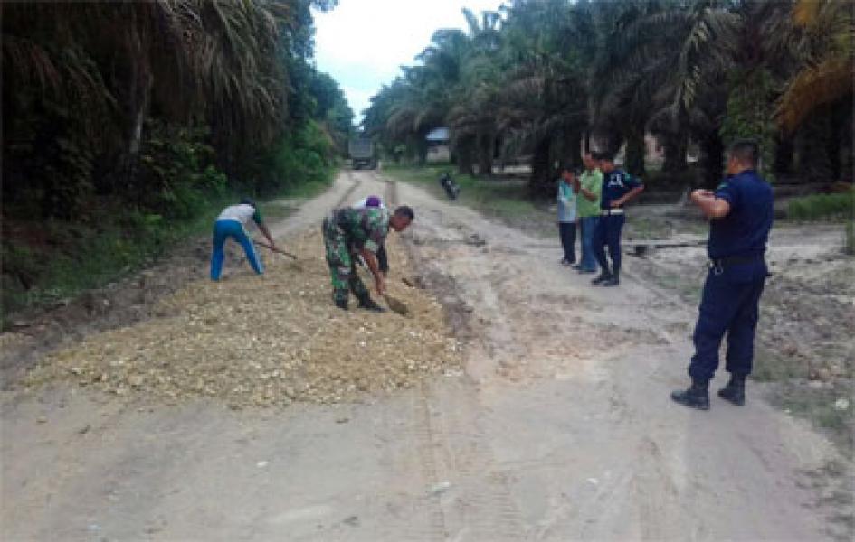 Babinsa Koramil 09/Langgam Bantu Warga Timbun Jalan Rusak
