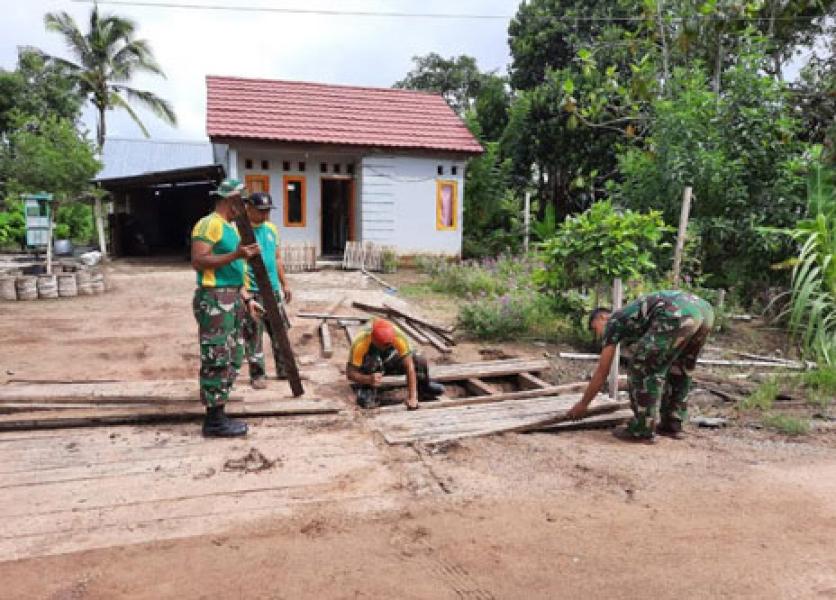 Personel Satgas Pamtas Yonif 411 Kostrad Bantu Perbaiki Jembatan Rumah Warga