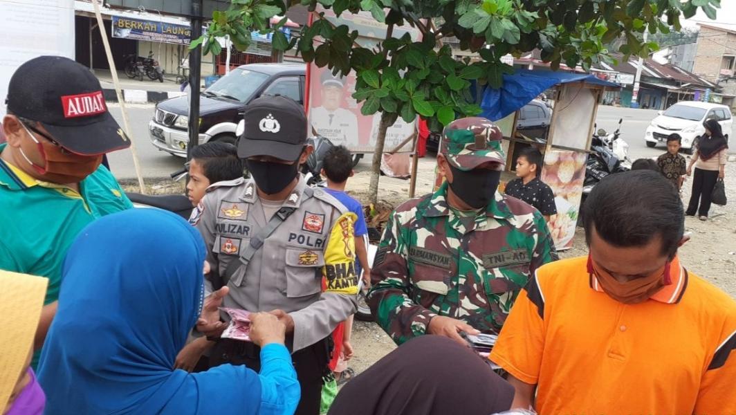 Babinsa Koramil 02/Rambah Bersama Bhabinkamtibmas dan Perangkat Desa Bagikan Masker ke Masyarakat