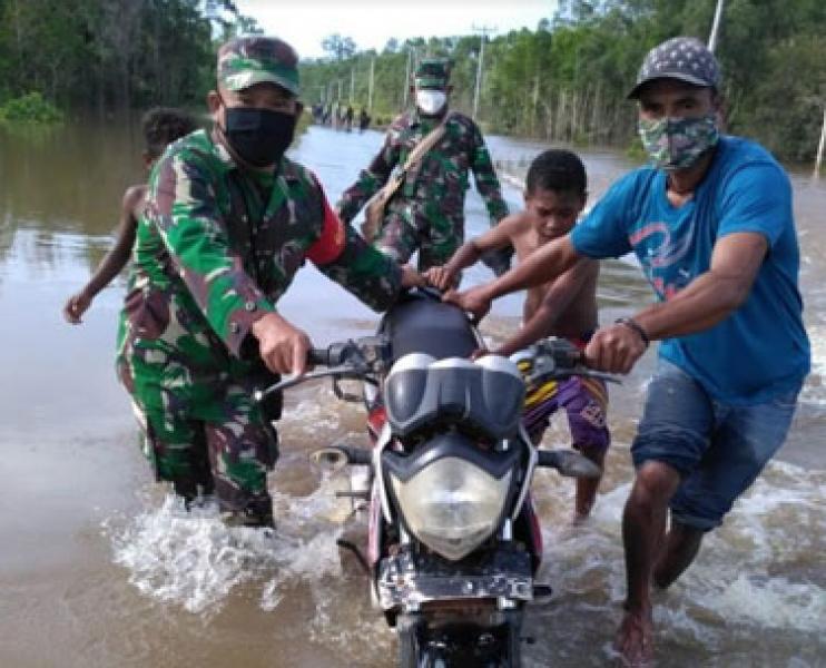 Anggota Koramil 1707-17 Bersama Polsek Bupul Bantu Pengendara Terjebak Banjir di Jalan Trans Papua