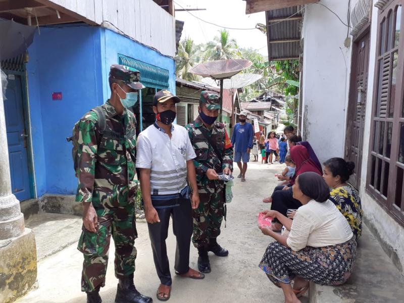 Cegah Corona, Babinsa Bersama Kepala Desa Batu Sanggan Bagikan Masker Gratis 
