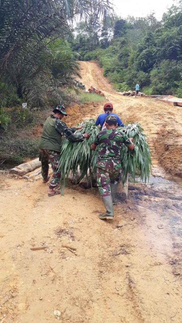 Ikhlas, Anggota Satgas TMMD Ke 105 Kodim 0313 KPR Bantu Warga Menyeberangi Jembatan Desa