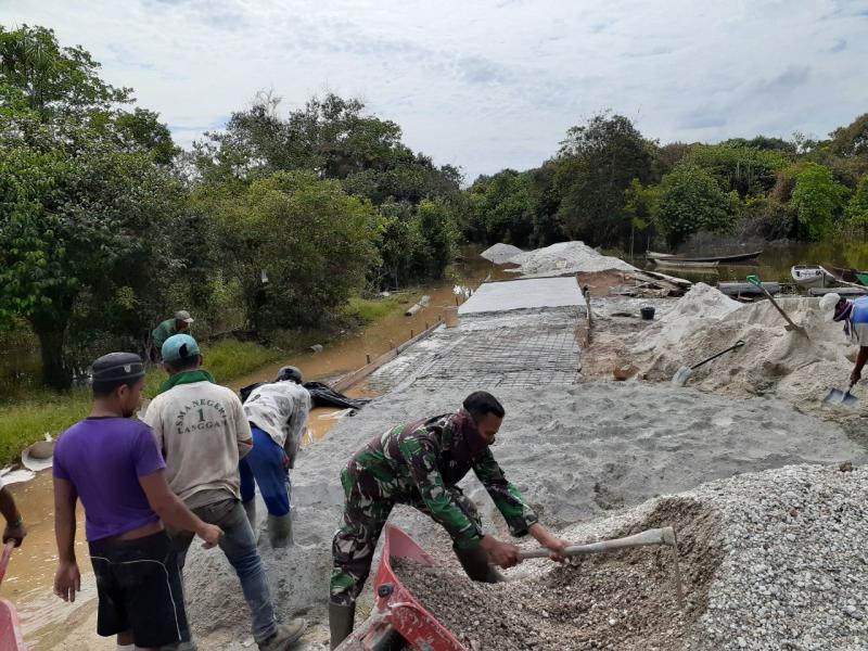 Babinsa 09/Langgam Goro Bantu Warga Semenisasi Jalan Desa Tambak