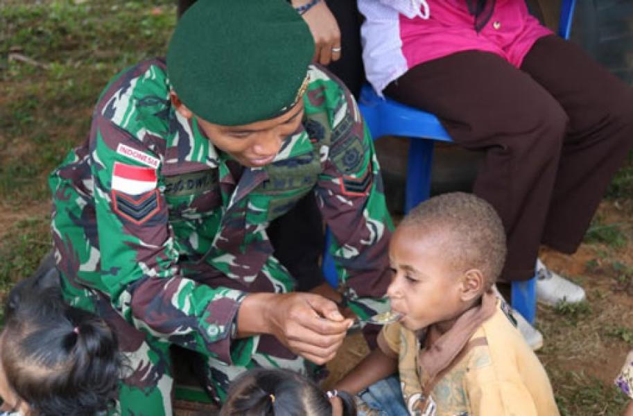 Satgas Pamtas RI-PNG Yonif 411 Kostrad Ajak Anak-Anak Makan Bubur Bersama
