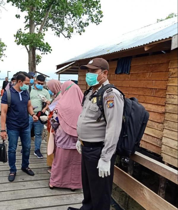 Bhabinkamtibmas Polsek Sungai Apit Bersama Petugas Syahbandar dan Kesehatan, Cek Suhu Tubuh Penumpang di Pelabuhan Buton